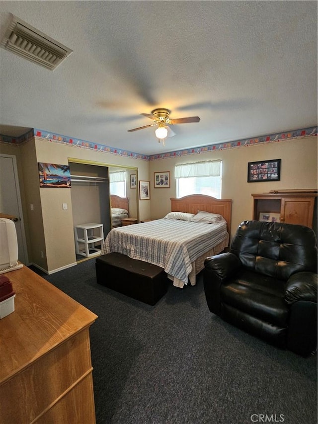 bedroom with visible vents, ceiling fan, a textured ceiling, and carpet