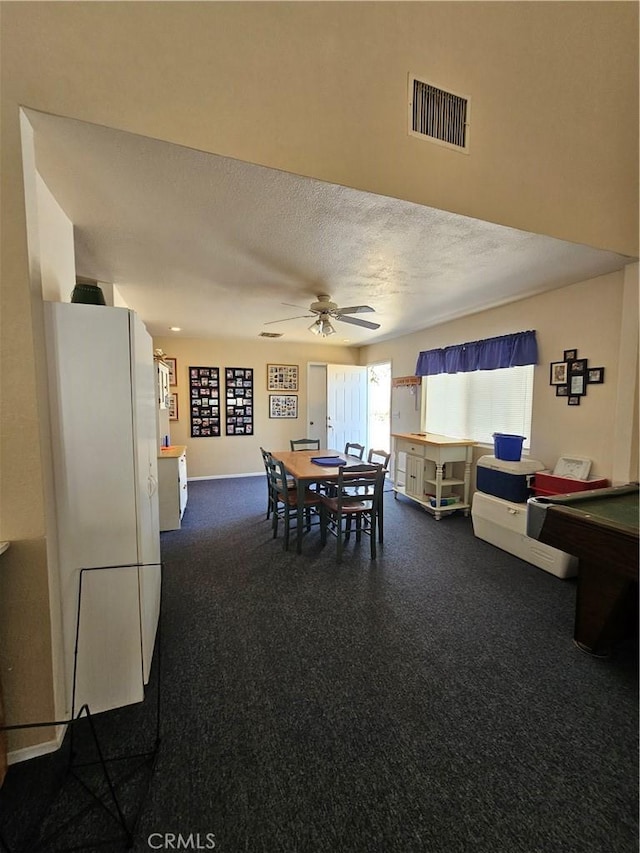 dining room featuring a ceiling fan, visible vents, and a textured ceiling