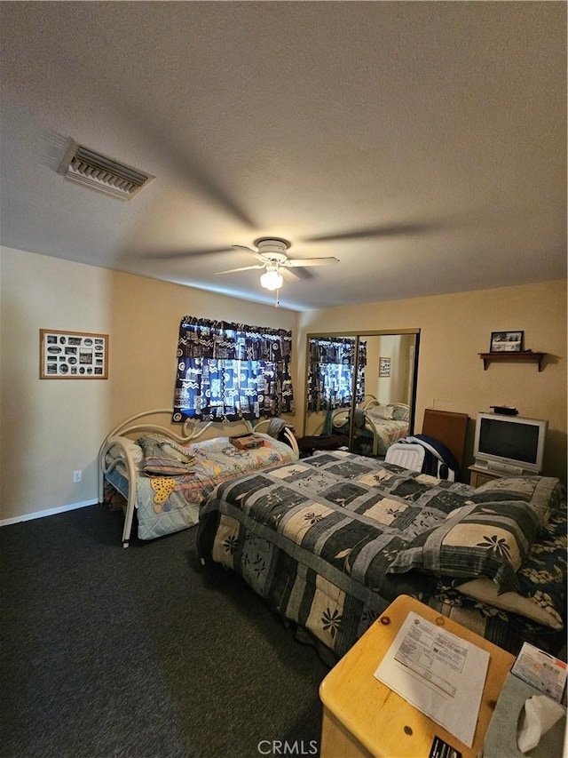 carpeted bedroom with visible vents, a textured ceiling, and ceiling fan