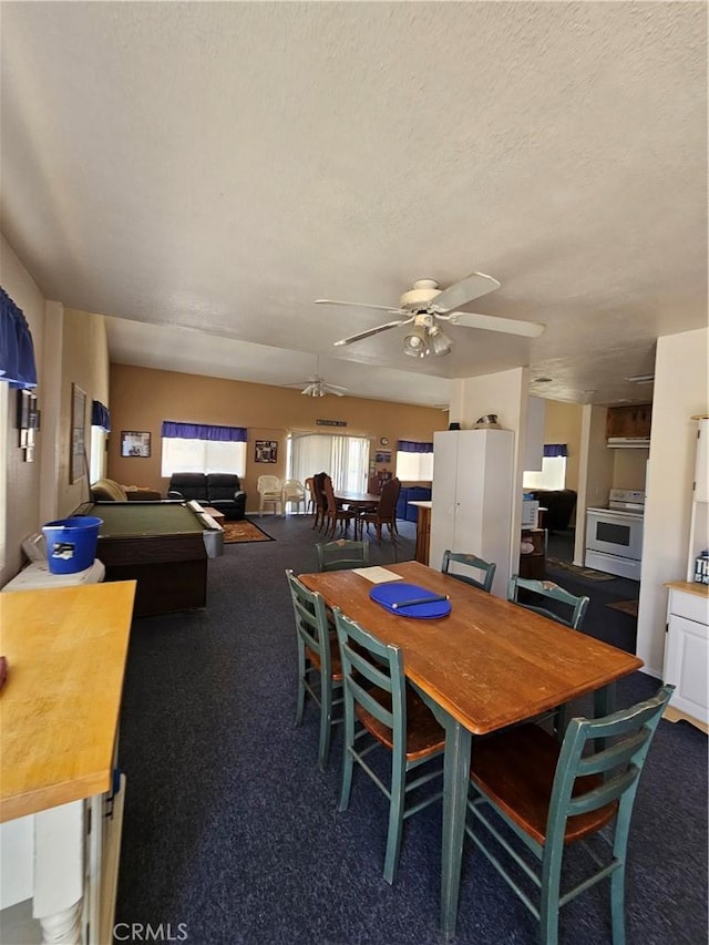 carpeted dining space with a textured ceiling and a ceiling fan