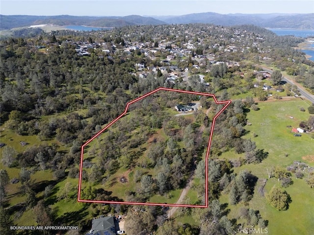 aerial view featuring a wooded view and a water and mountain view
