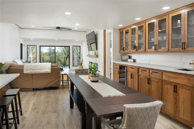 interior space with light wood finished floors, recessed lighting, and beverage cooler