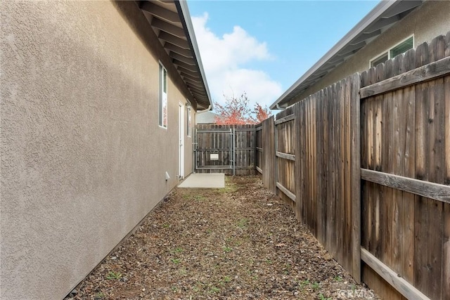 view of side of home featuring stucco siding and a fenced backyard