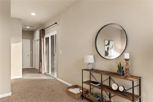 hallway with recessed lighting, visible vents, baseboards, and carpet