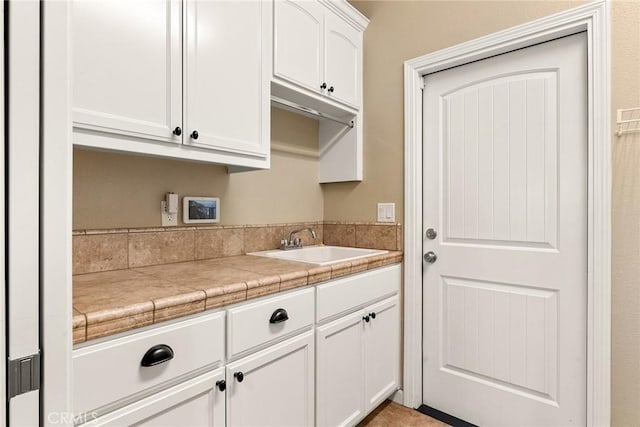 kitchen featuring white cabinetry and a sink