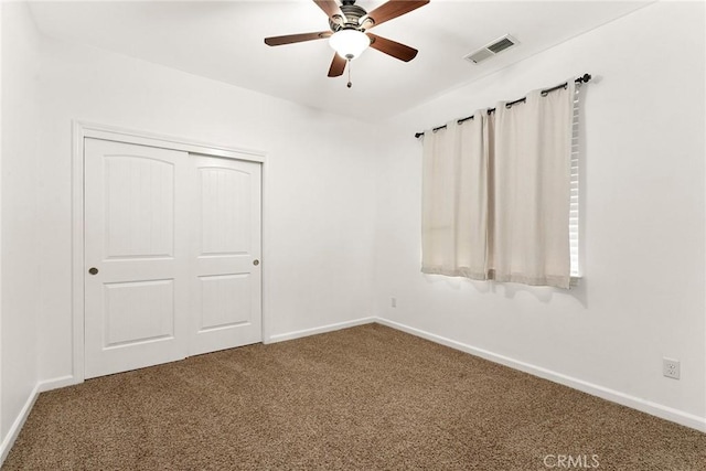 carpeted spare room featuring a ceiling fan, baseboards, and visible vents