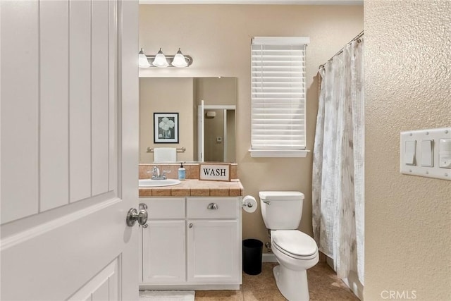 bathroom with a shower with curtain, toilet, vanity, and tile patterned flooring