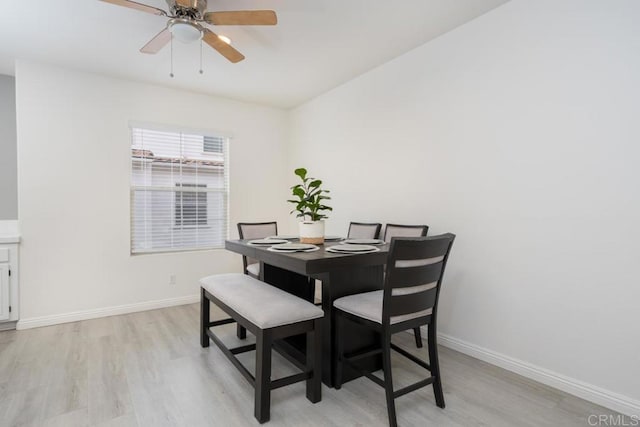 dining area featuring a ceiling fan, light wood-style floors, and baseboards