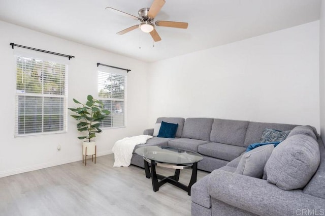 living room featuring wood finished floors, baseboards, and ceiling fan