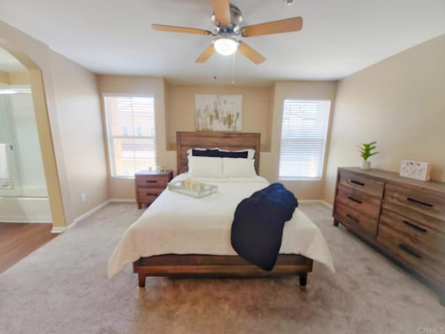 2203 Huntington Point Dr Unit 4, Chula Vista, CA 91914 - bedroom featuring arched walkways, light carpet, multiple windows, and baseboards