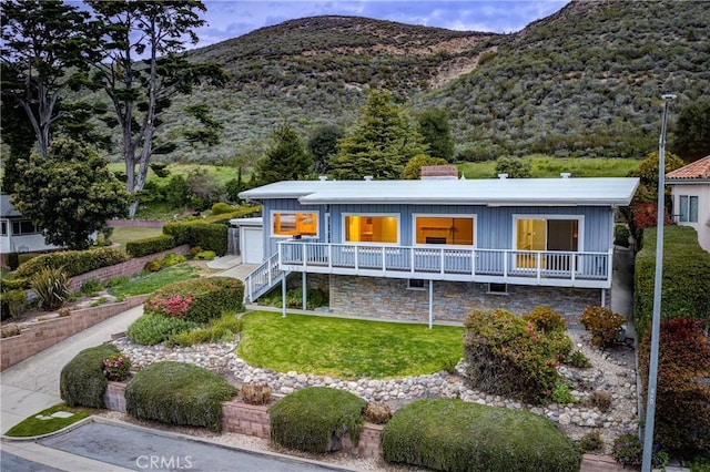 view of front of house featuring a front lawn, a garage, and a mountain view