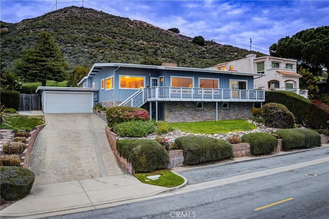 view of front of property with concrete driveway, a garage, and stone siding