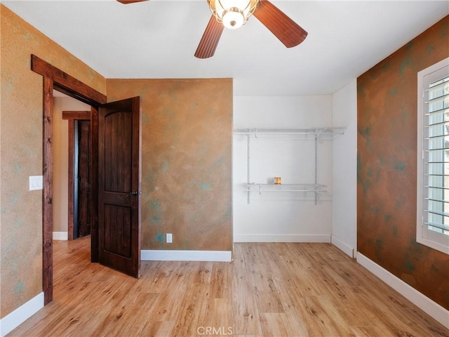 unfurnished bedroom featuring multiple windows, wood finished floors, and baseboards