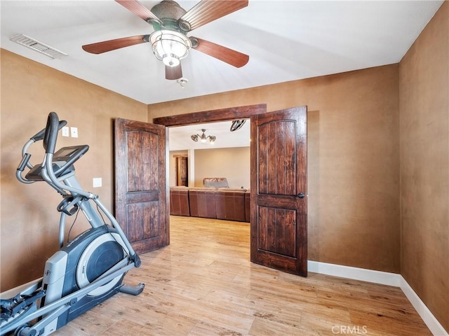 exercise area with ceiling fan, visible vents, baseboards, and light wood-style flooring