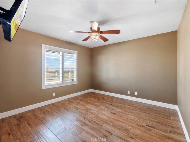 spare room with light wood-style flooring, baseboards, and ceiling fan