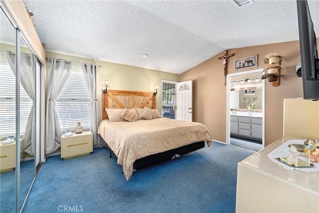 bedroom with visible vents, a textured ceiling, connected bathroom, carpet flooring, and lofted ceiling