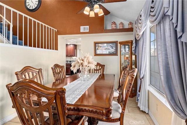 dining area with visible vents, a ceiling fan, light tile patterned floors, baseboards, and vaulted ceiling