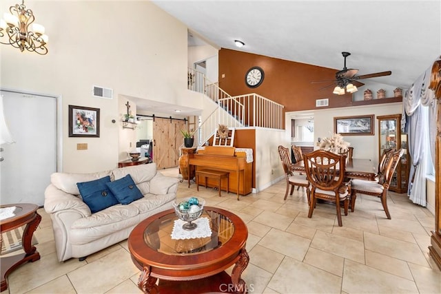 living area with visible vents, ceiling fan with notable chandelier, stairs, and a barn door