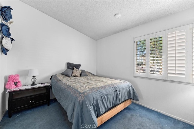 bedroom featuring vaulted ceiling, baseboards, carpet floors, and a textured ceiling