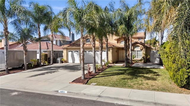 mediterranean / spanish home with a front lawn, a tiled roof, concrete driveway, stucco siding, and an attached garage