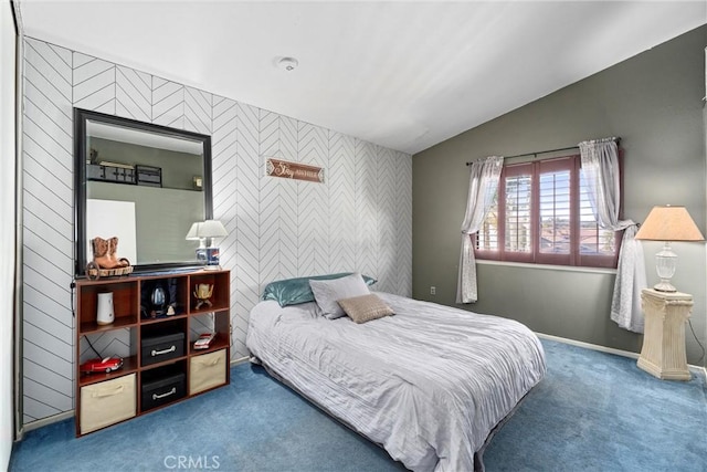 bedroom featuring carpet, an accent wall, baseboards, and vaulted ceiling