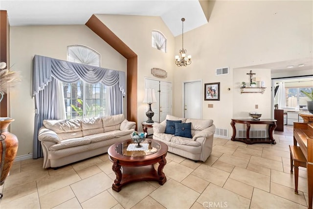 living room with a notable chandelier, light tile patterned flooring, visible vents, and baseboards