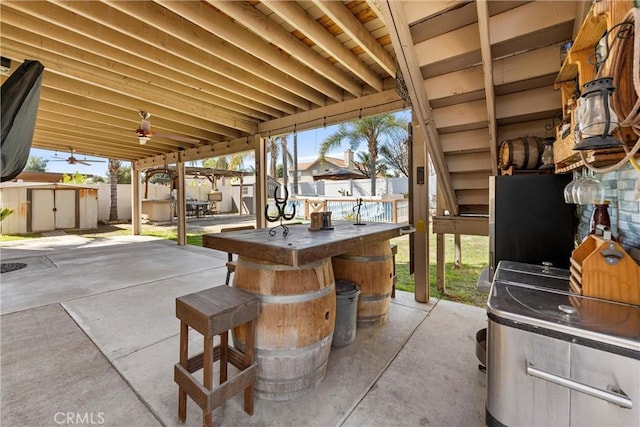 view of patio featuring an outdoor structure, a storage unit, and a fenced backyard