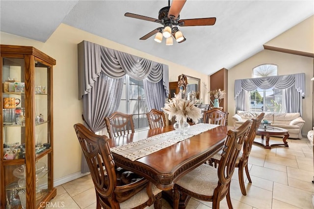 dining room with lofted ceiling, light tile patterned floors, baseboards, and ceiling fan