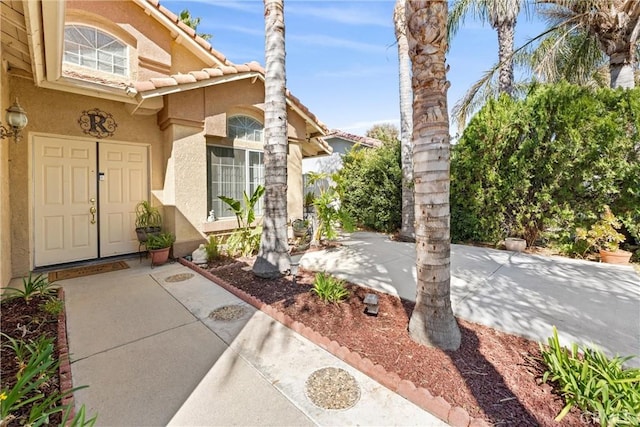 property entrance featuring stucco siding and a tiled roof