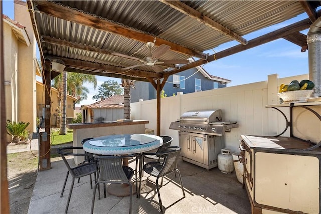 view of patio featuring outdoor dining space, fence, and a ceiling fan