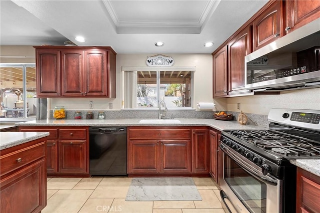 kitchen featuring ornamental molding, a sink, a tray ceiling, appliances with stainless steel finishes, and dark brown cabinets