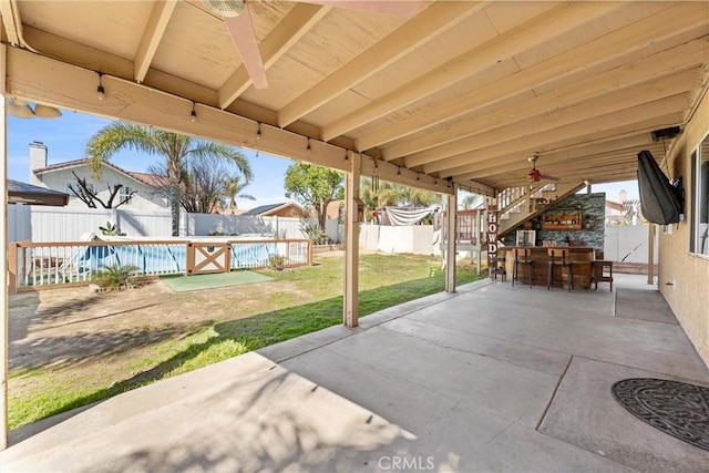 view of patio with a fenced backyard, a fenced in pool, and outdoor dry bar