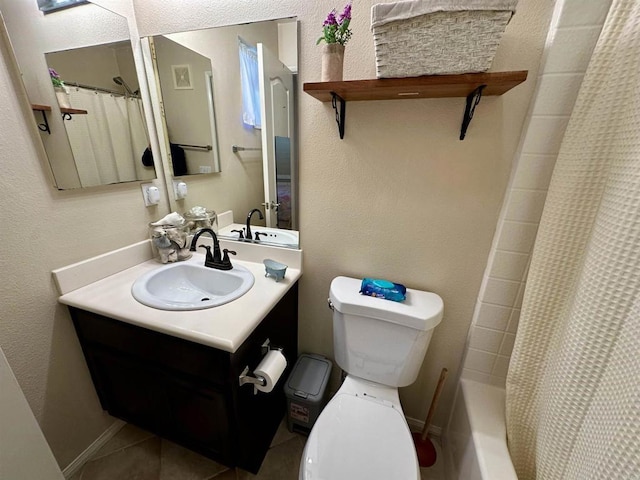 full bathroom with tile patterned floors, toilet, baseboards, vanity, and a textured wall