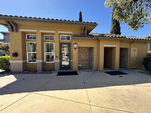 mediterranean / spanish home with stucco siding, a tiled roof, concrete driveway, and a garage