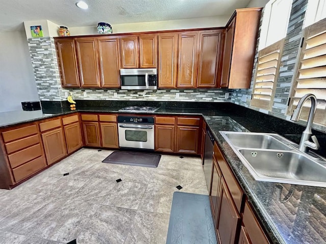 kitchen featuring a sink, stainless steel appliances, brown cabinets, and backsplash