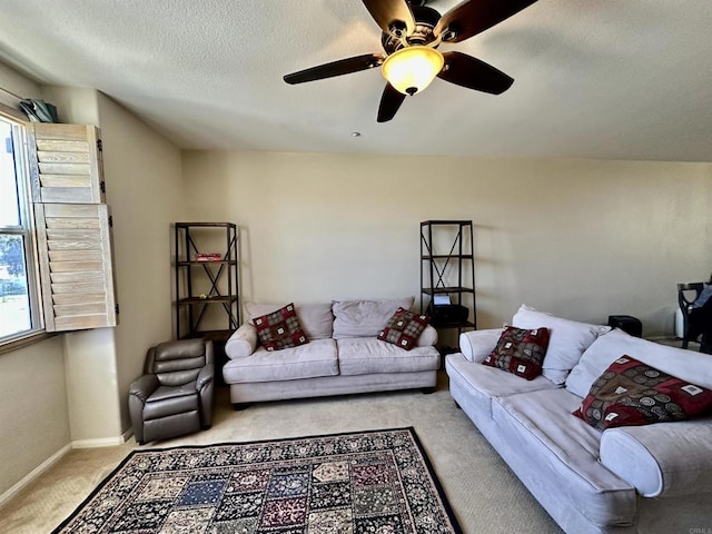 living room featuring a ceiling fan, baseboards, carpet floors, and a textured ceiling