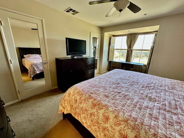 carpeted bedroom with visible vents, a ceiling fan, and baseboards