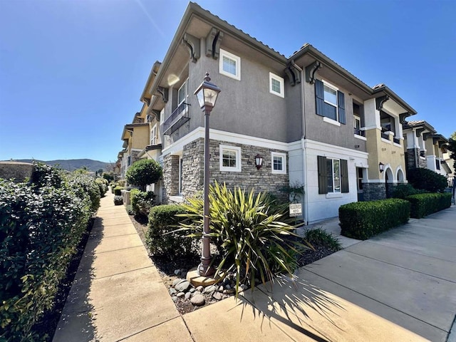 view of property exterior featuring stone siding and stucco siding