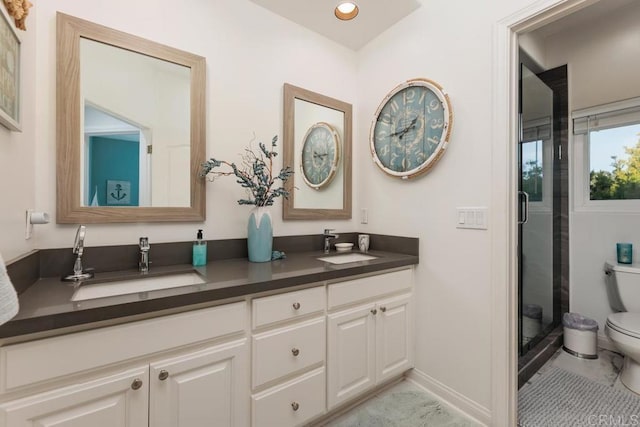 bathroom with double vanity, toilet, a stall shower, and a sink