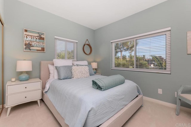 bedroom with baseboards and light colored carpet