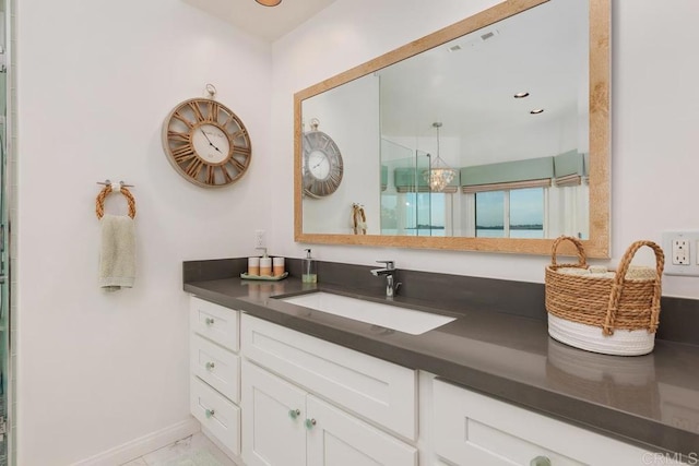 full bathroom featuring a shower with shower door, baseboards, and vanity