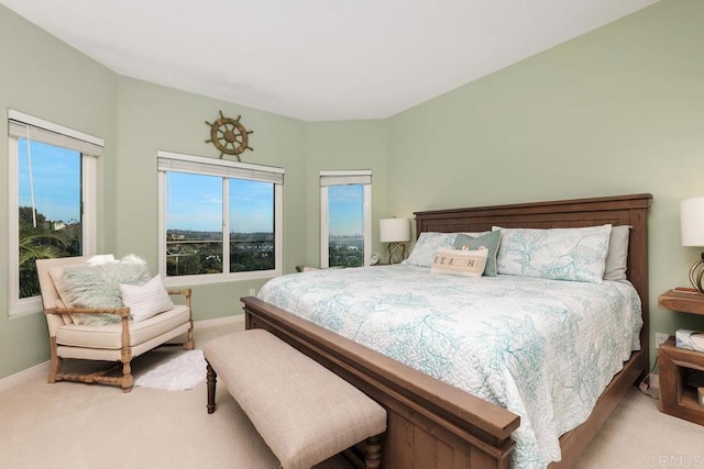 bedroom with light colored carpet and baseboards