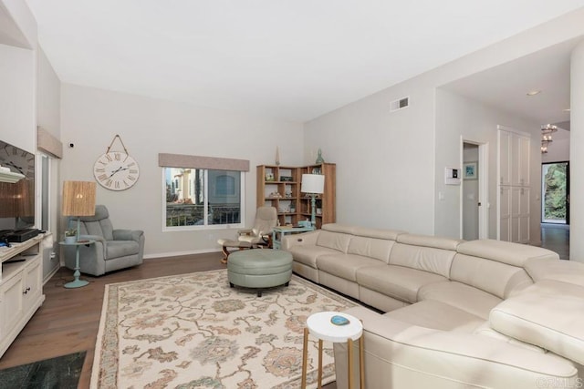 living room featuring visible vents, dark wood-style floors, and baseboards