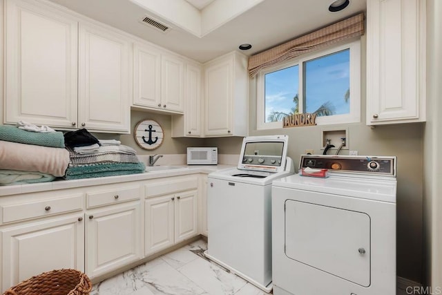 laundry area featuring visible vents, washer and dryer, cabinet space, marble finish floor, and a sink