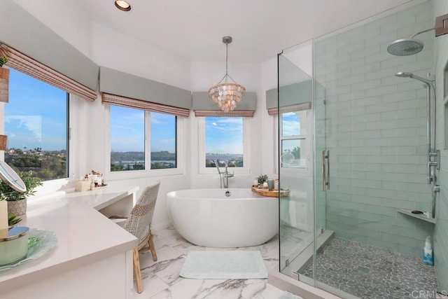 bathroom featuring a notable chandelier, marble finish floor, a stall shower, and a freestanding tub