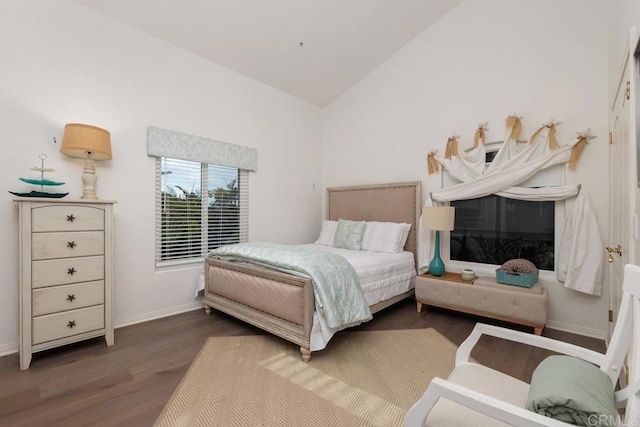 bedroom with vaulted ceiling, wood finished floors, and baseboards