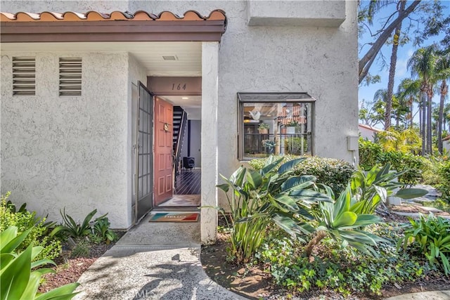 property entrance featuring stucco siding and a tile roof