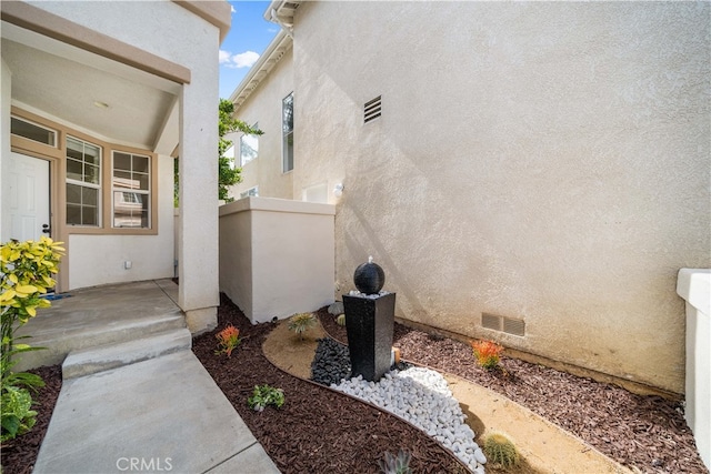 view of home's exterior with crawl space and stucco siding