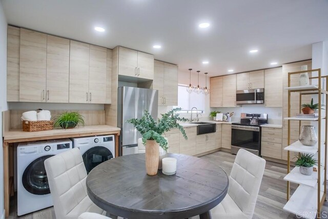 kitchen featuring a sink, washer / dryer, appliances with stainless steel finishes, and light brown cabinetry