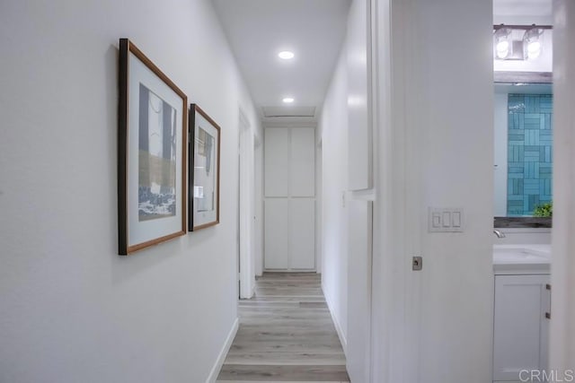 4197 Tiberon Dr, Oceanside, CA 92056 - hall featuring light wood finished floors, recessed lighting, baseboards, and a sink
